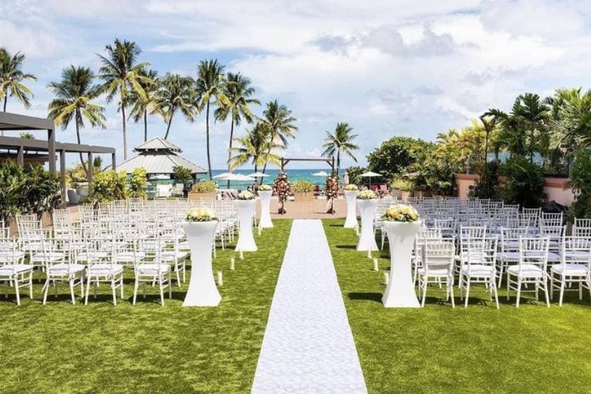 White ceremony seating on the oceanfront lawn under the palms